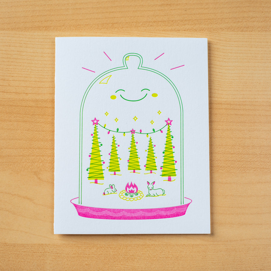 Letterpress holiday greeting card of a smiling terrarium filled with Christmas trees