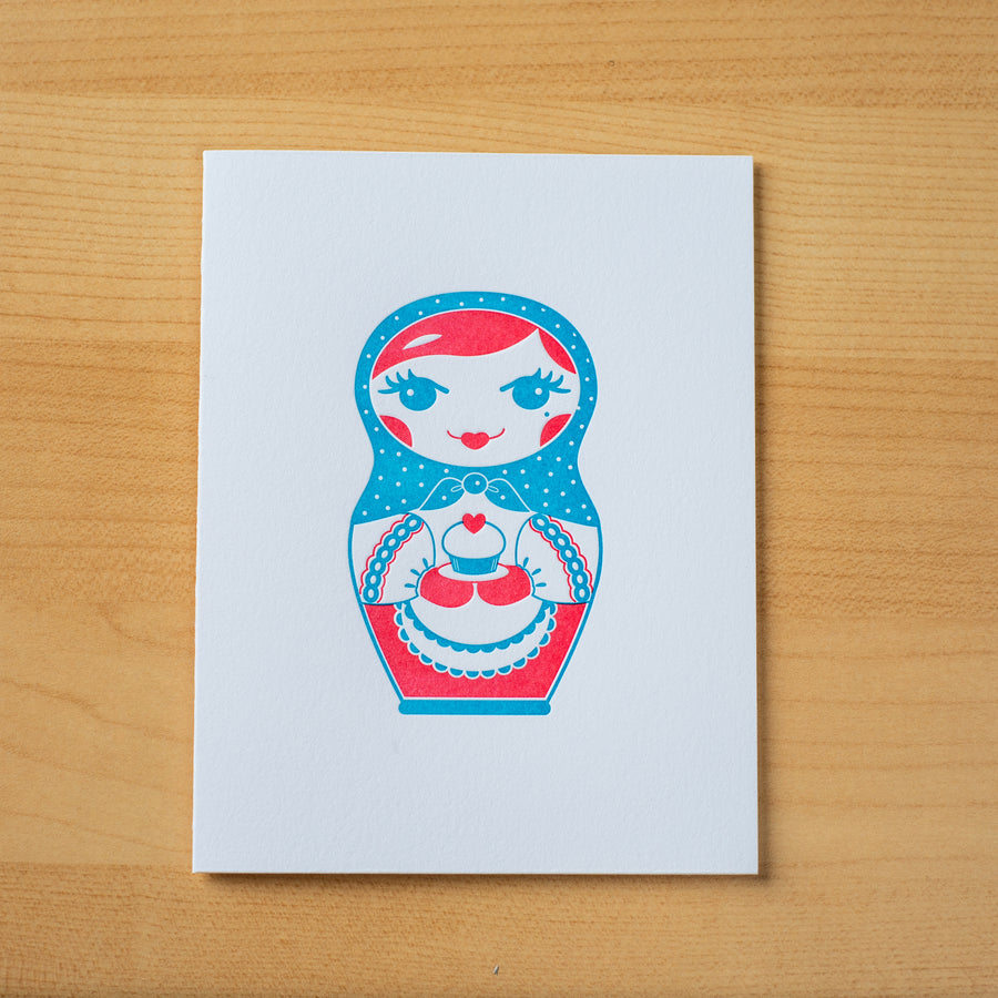 Letterpress birthday greeting card of nesting doll holding cupcake