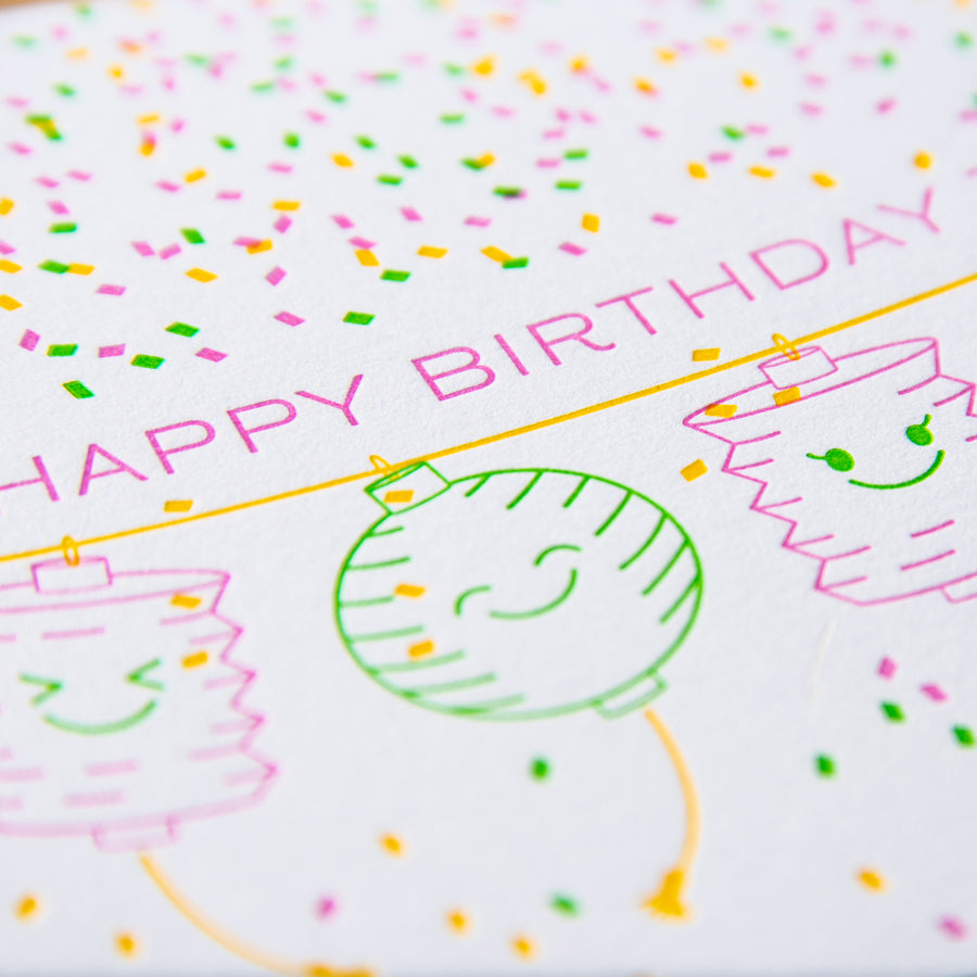 Letterpress birthday greeting card of paper lanterns and confetti