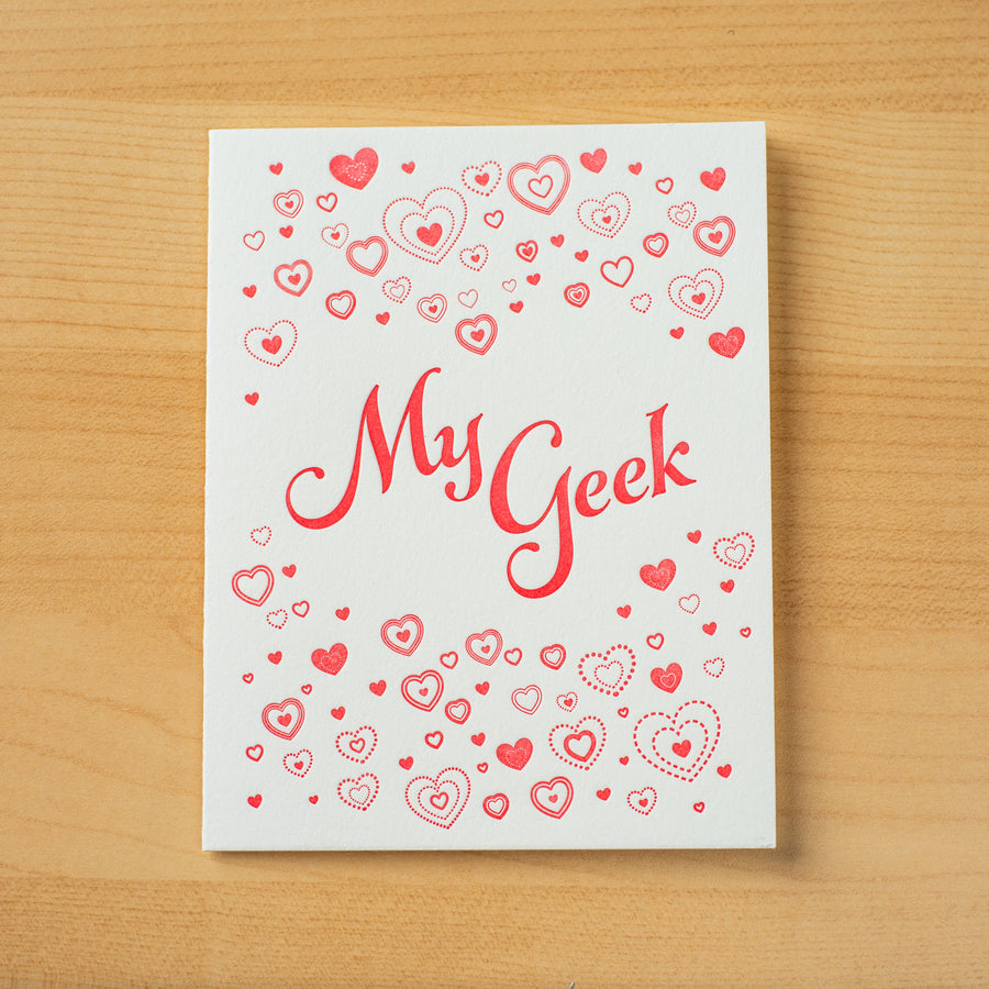 Letterpress Valentine greeting card with small red hearts encircling the phrase My Geek